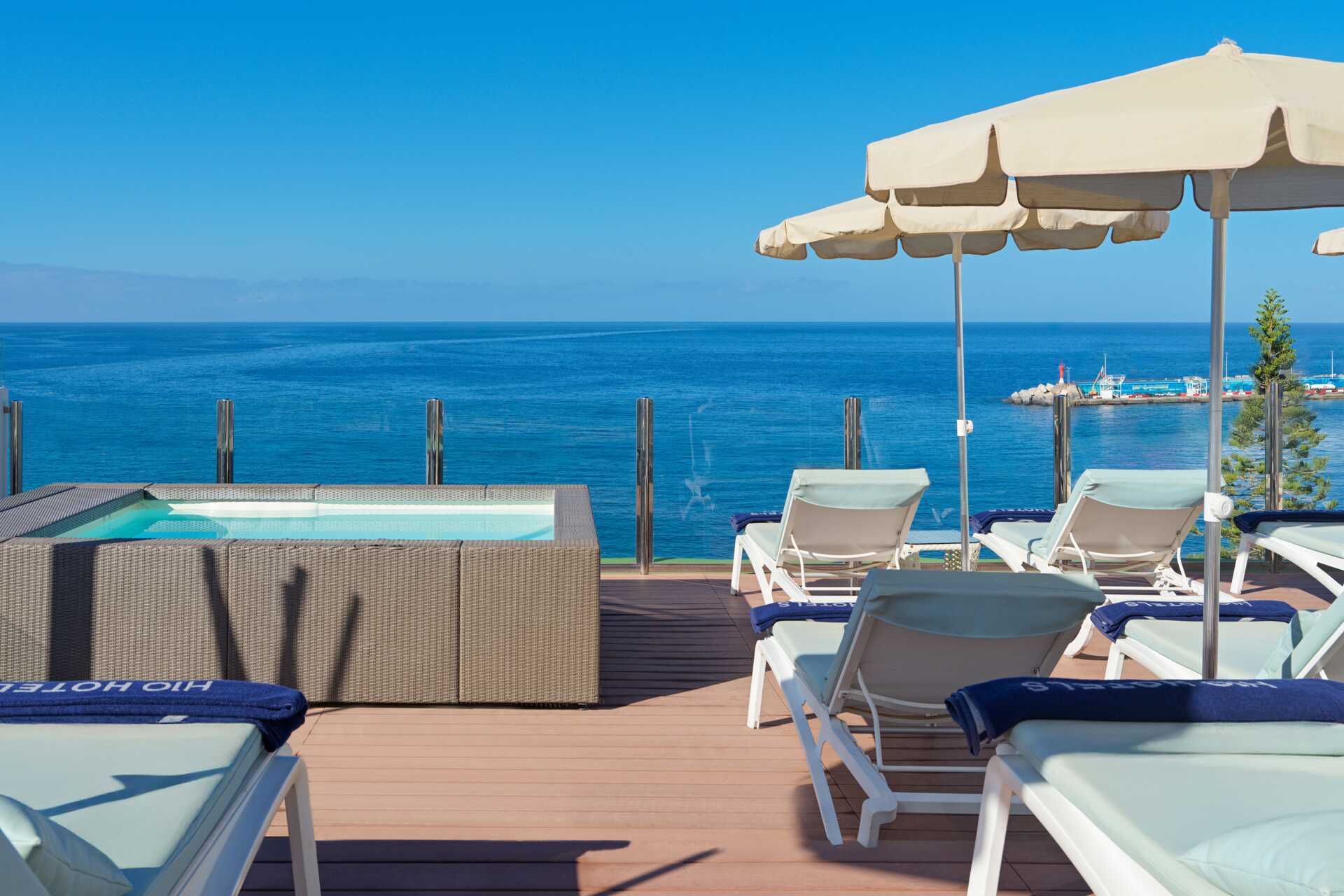 Takterrasse med boblebad og solsenger, med utsikt over havet